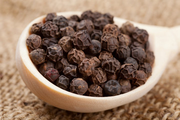 black pepper on wooden spoon