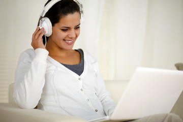 Charming female with headphone listening music