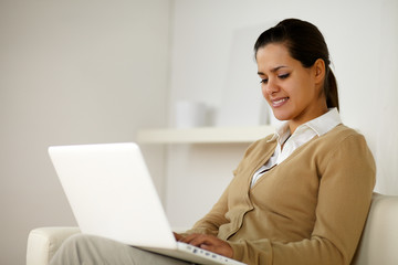 Charming latin young female using her laptop