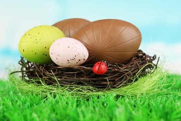 Composition of Easter and chocolate eggs in nest