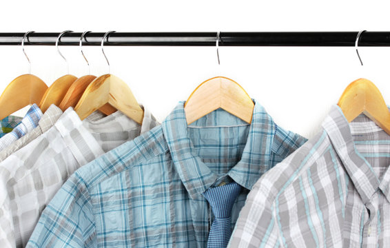 Shirts with ties on wooden hangers on light background