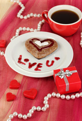 Chocolate cookie in form of heart with cup of coffee