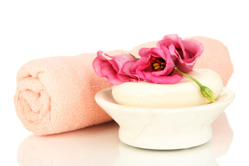 Obraz na płótnie Canvas Rolled pink towel, soap bar and beautiful flower isolated