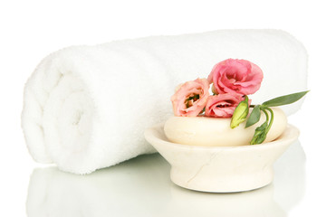 Fototapeta na wymiar Rolled white towel, soap bar and beautiful flower isolated