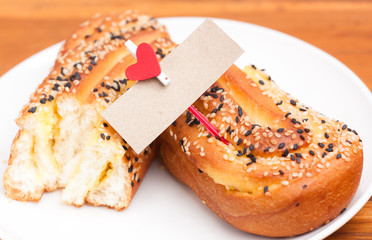 delicious breads with sesame and card bank paper and hearts on t