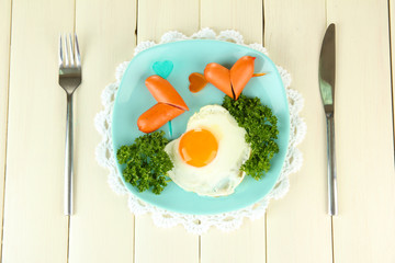 Sausages in form of hearts, scrambled eggs and parsley,