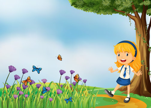 A young school girl in the garden with butterflies