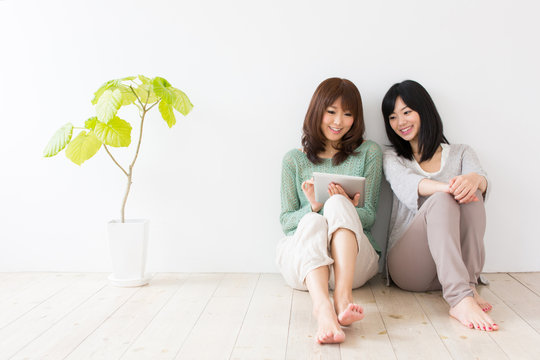attractive asian women using tablet computer in the room