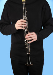 Fototapeta premium Musician playing clarinet with hands on keys, woodwind instrument performance and music education, intricate details of the clarinet and the focused engagement of the player