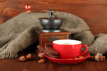 Dark chocolate, hot drink and coffee mill on wooden background