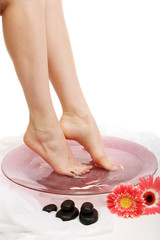 Obraz na płótnie Canvas Female feet in spa bowl with water, isolated on white