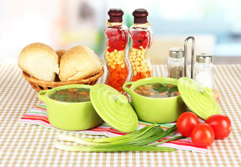Fragrant soup in pans on table in kitchen