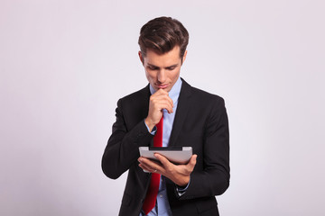 pensive man holding tablet