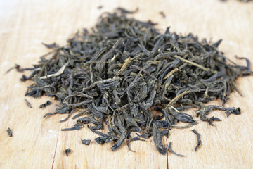 Fototapeta na wymiar Dry green tea on wooden background