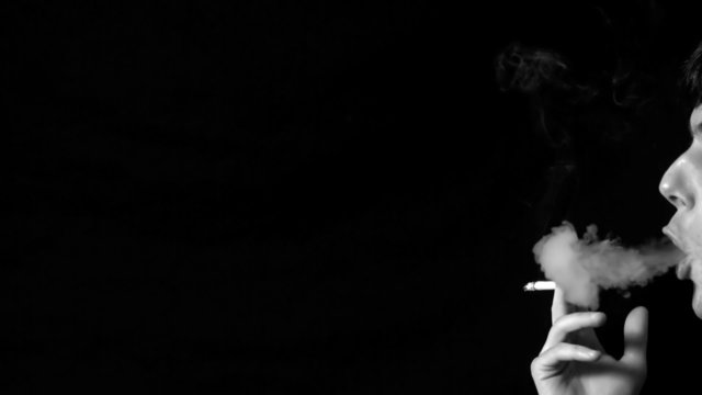 Man blowing out cigarette smoke