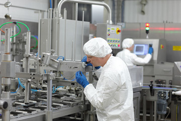 two workers at production line in plant