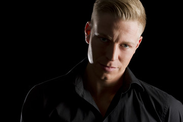 Obraz premium Low key portrait of young alluring man looking straight.