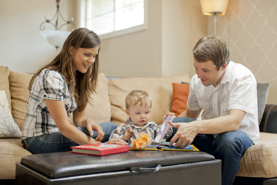 Caucasian couple playing with son in living room
