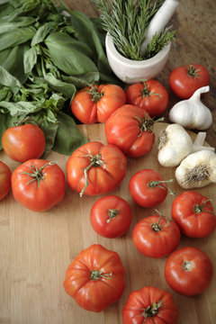 Tomatoes, garlic and basil on cutting board