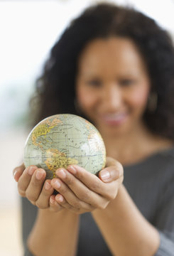 Hispanic woman holding small globe