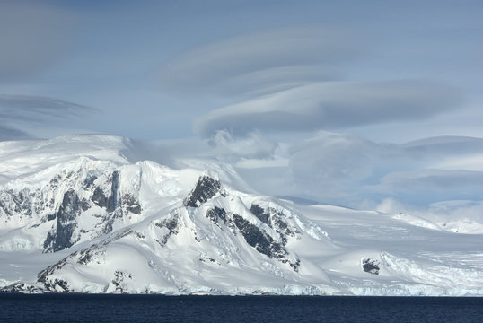 Mountains of western Antarctic Peninsula in cloudy day.