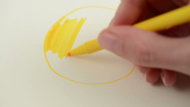 drawing a yellow happy smiley face with a felt-tip pen