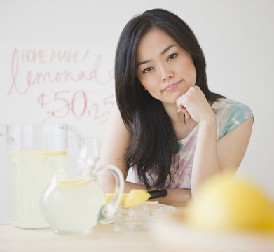 Frustrated Japanese woman sitting at lemonade stand