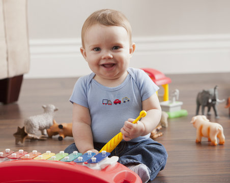 Caucasian baby boy playing with xylophone