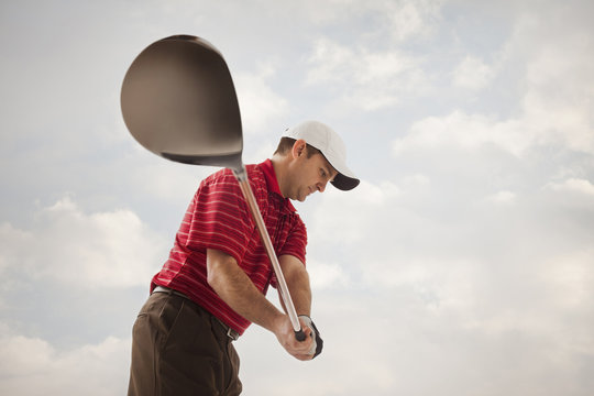Caucasian golfer swinging golf club