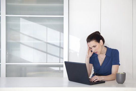 Caucasian businesswoman using laptop at desk