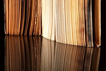 Open old book with vintage pages reflected