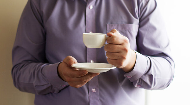 Businessman holding a cup of coffee - Powered by Adobe