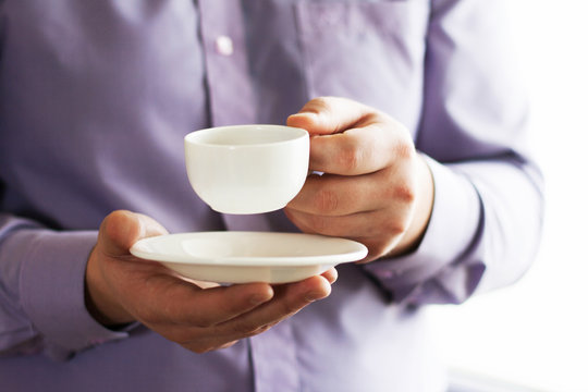 Businessman holding a cup of coffee - Powered by Adobe
