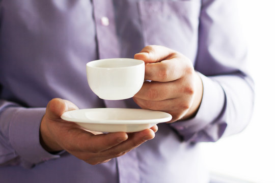 Businessman holding a cup of coffee - Powered by Adobe