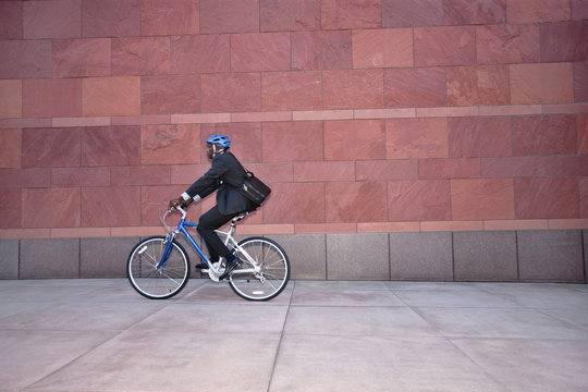 Businessman riding bicycle on sidewalk