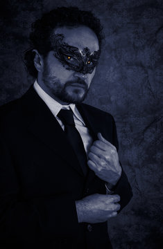 Vampire masked mystery man and elegant black suit over vintage b