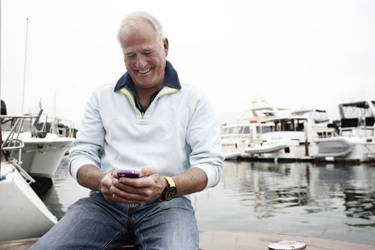 Man using cell phone in marina