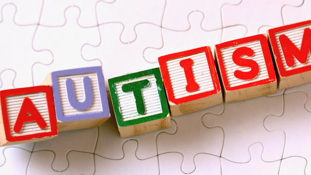 Autism blocks falling onto jigsaw surface