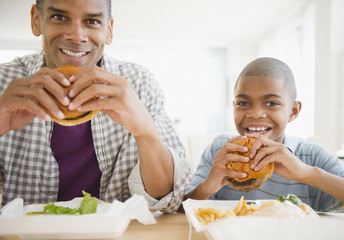 Father and son eating hamburgers