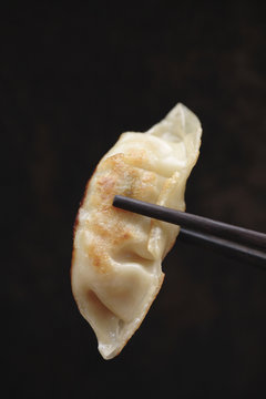 Chopsticks holding Asian dumpling