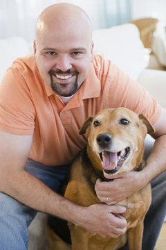Smiling man hugging dog