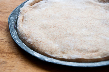 Whole wheat pizza dough rising in a pan