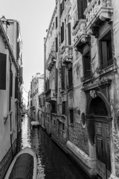 Black and white Venice channel with aged ruined buildings