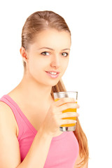 Female athlete holding a glass of orange juice, refreshing after