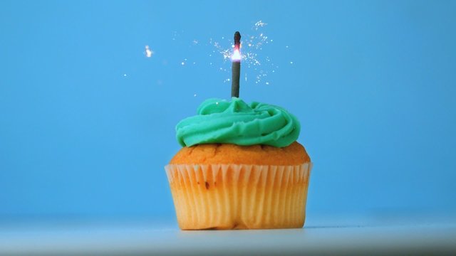 Sparkler burning on blue birthday cupcake