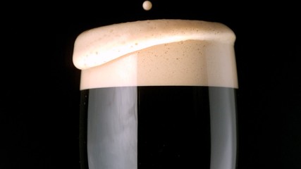 Foam head settling on pint of stout