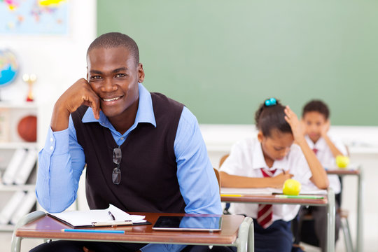handsome african school teacher in classroom