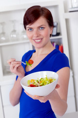 young woman offering a healthy green salad
