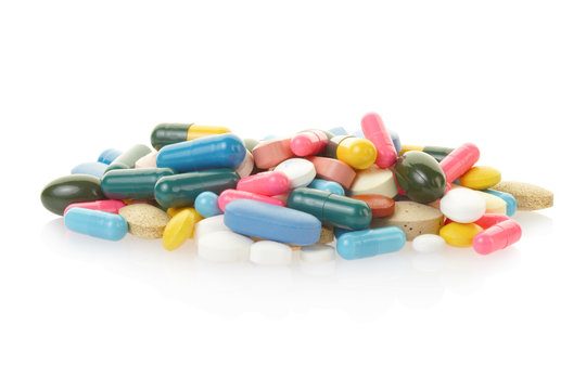Pill and colorful capsule heap on white, clipping path