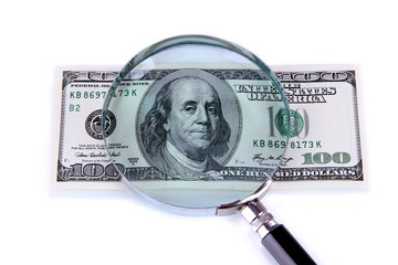 Hundred dollar bill and magnifying glass isolated on white